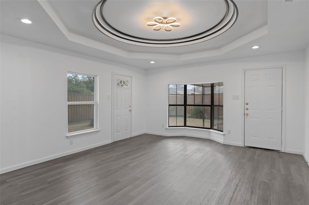 4606 Hazelhurst Lane Dallas, TX 75227 - Photo 10 of 30 an empty room with wooden floor and windows