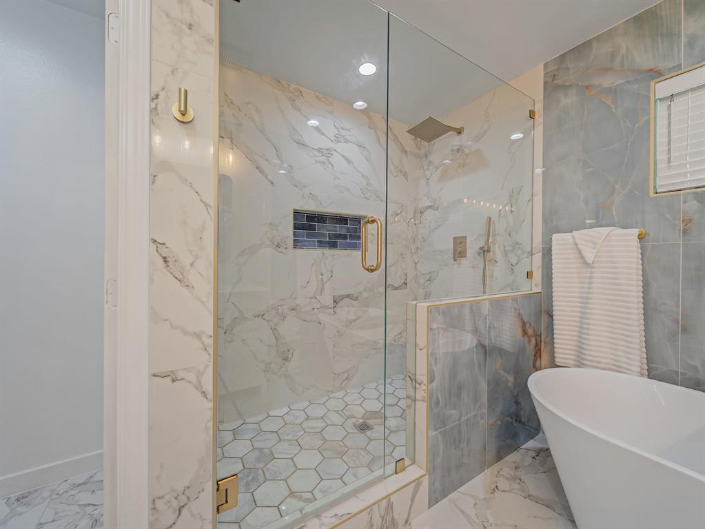 4606 Hazelhurst Lane Dallas, TX 75227 - Photo 14 of 30 a bathroom with a bathtub and a shower