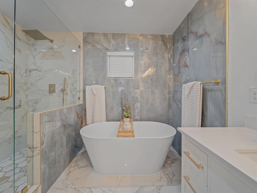 4606 Hazelhurst Lane Dallas, TX 75227 - Photo 15 of 30 a bathroom with a bathtub and shower
