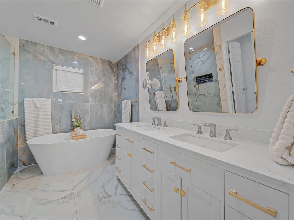 4606 Hazelhurst Lane Dallas, TX 75227 - Photo 16 of 30 a spacious bathroom with a double vanity sink mirror and bathtub