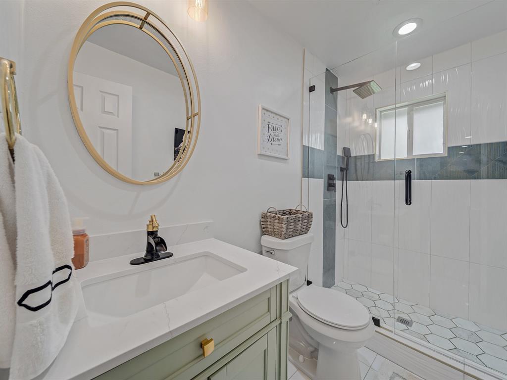 4606 Hazelhurst Lane Dallas, TX 75227 - Photo 20 of 30 a bathroom with a sink a toilet and a mirror
