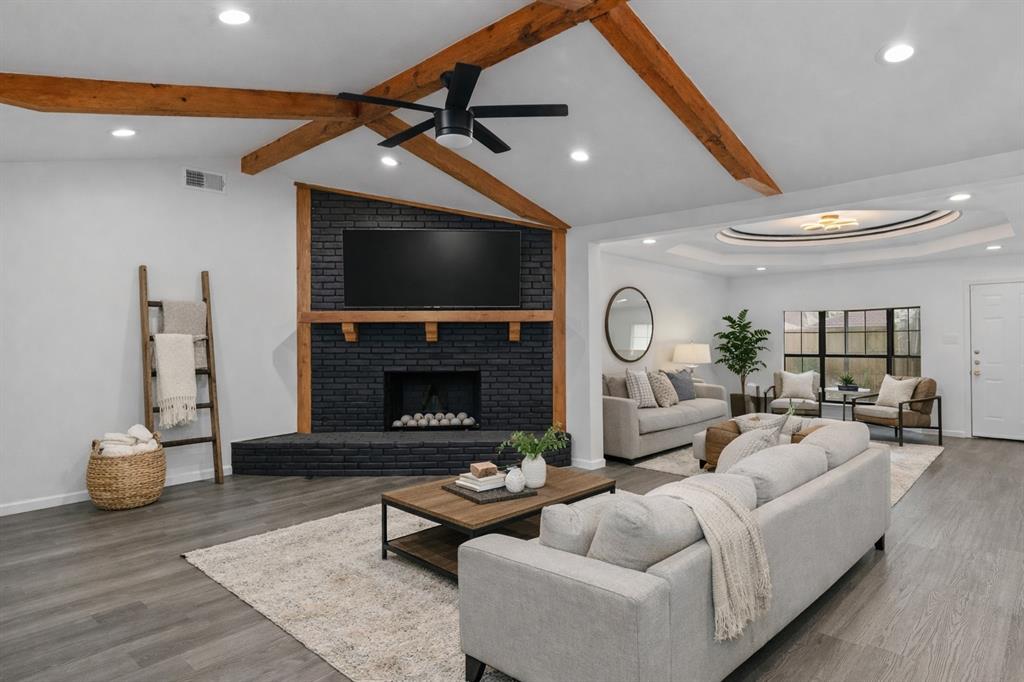 4606 Hazelhurst Lane Dallas, TX 75227 - Photo 4 of 30 a living room with furniture a fireplace and a flat screen tv