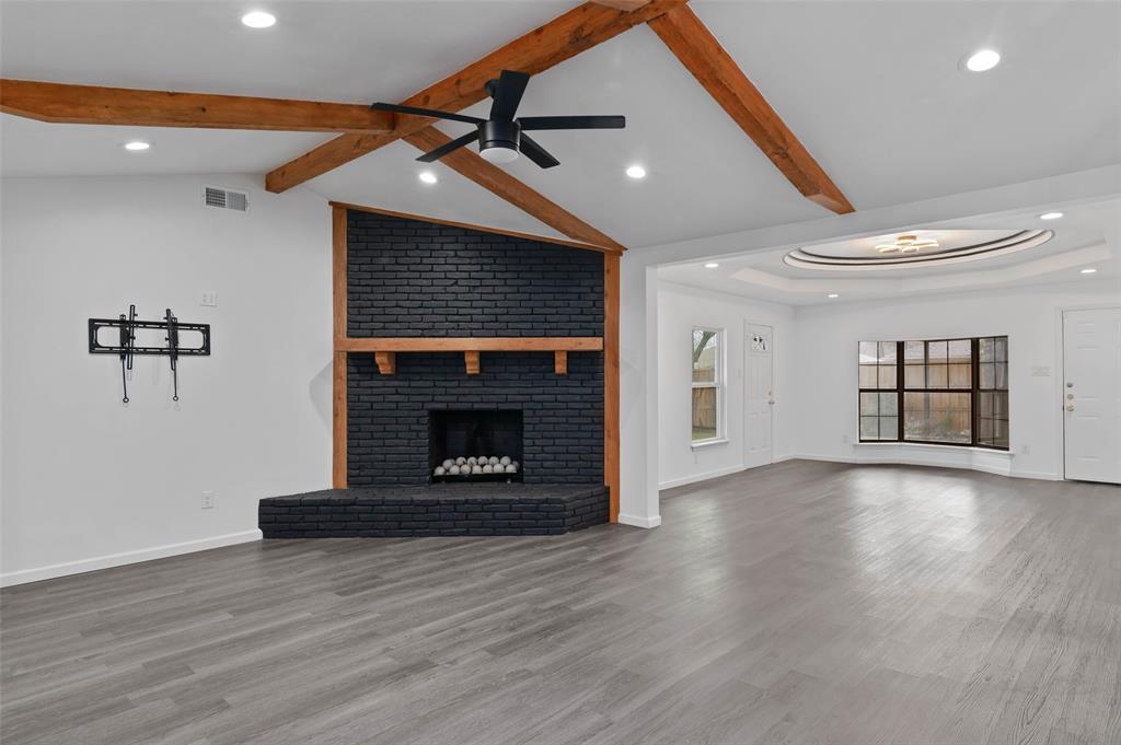 4606 Hazelhurst Lane Dallas, TX 75227 - Photo 5 of 30 a view of an empty room with wooden floor fireplace and a window