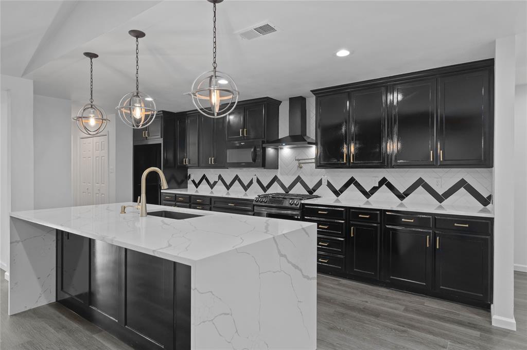 4606 Hazelhurst Lane Dallas, TX 75227 - Photo 8 of 30 a kitchen with stainless steel appliances granite countertop a sink a stove and a wooden floors