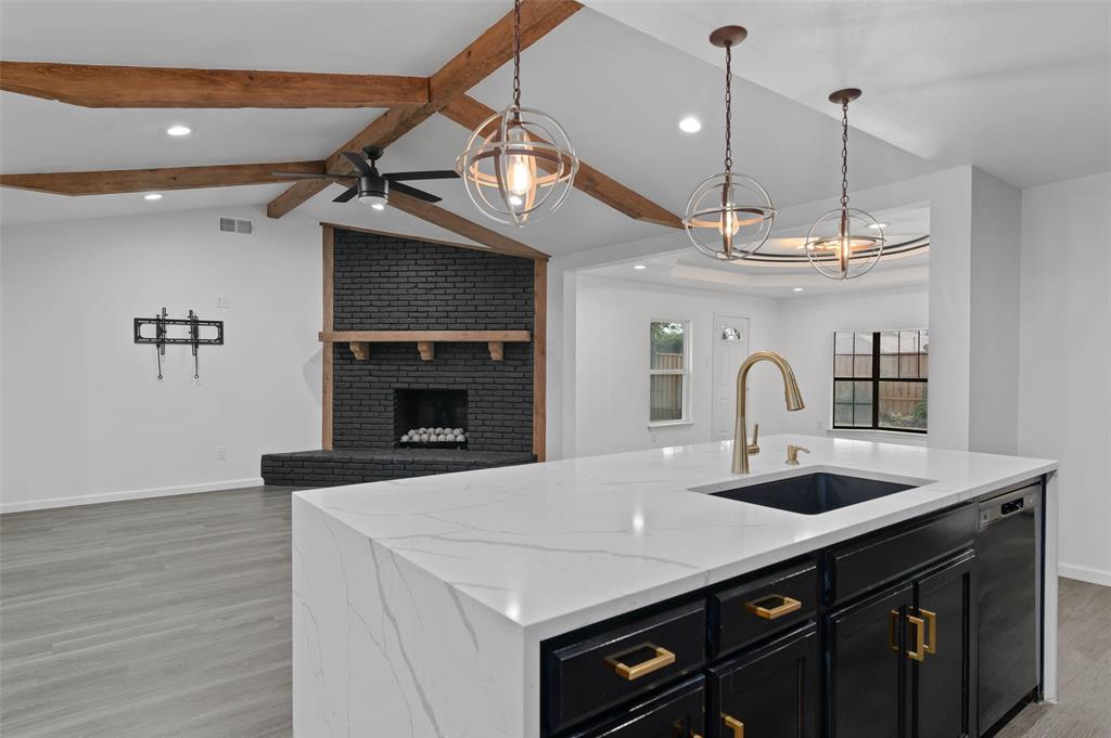 4606 Hazelhurst Lane Dallas, TX 75227 - Photo 30 of 30 a kitchen with a sink a kitchen island a stove and a wooden floor