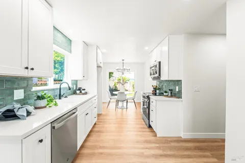 a view of a kitchen with kitchen island a window a counter space and stainless steel appliances