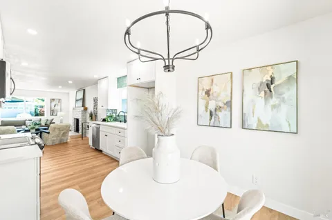 a kitchen with white cabinets and wooden floors