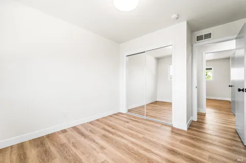 an empty room with wooden floor and window