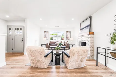 a living room with fireplace furniture and a wooden floor