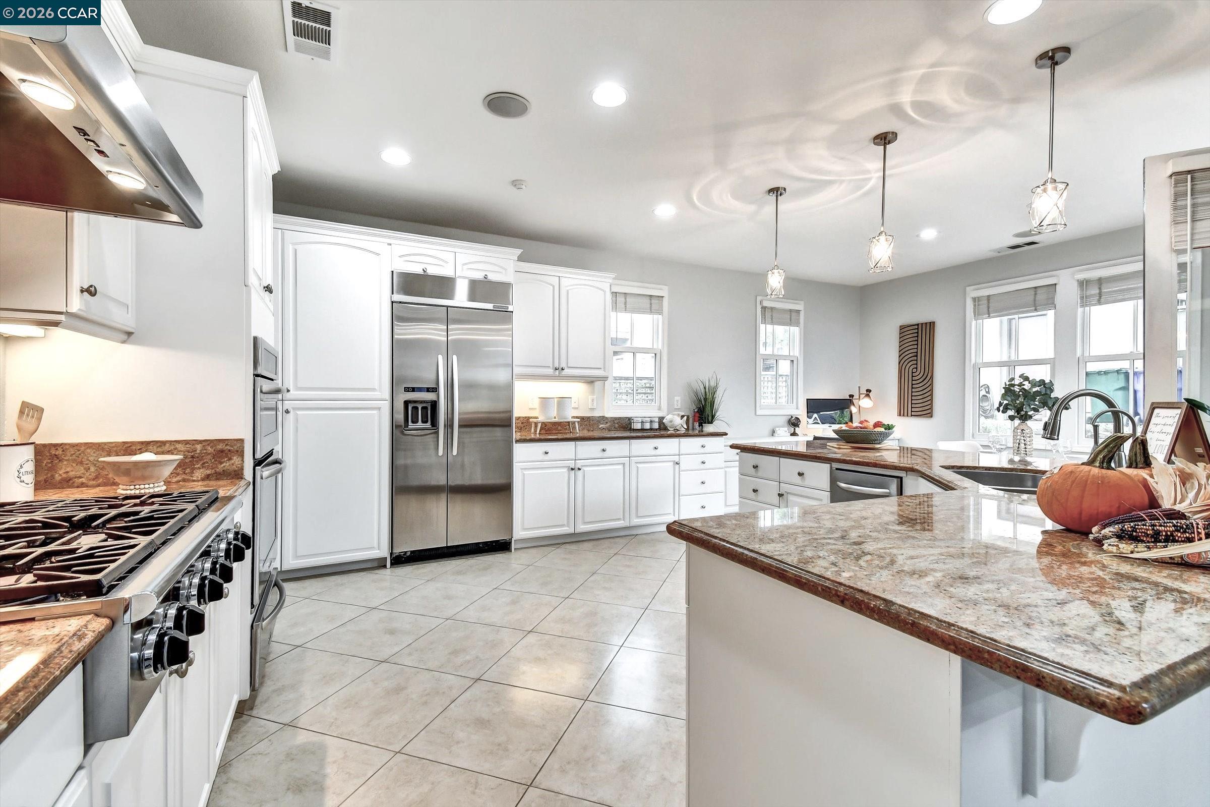 1018 Promenade Street Hercules, CA 94547 - Photo 19 of 60 a kitchen with stainless steel appliances granite countertop a stove a sink and a refrigerator