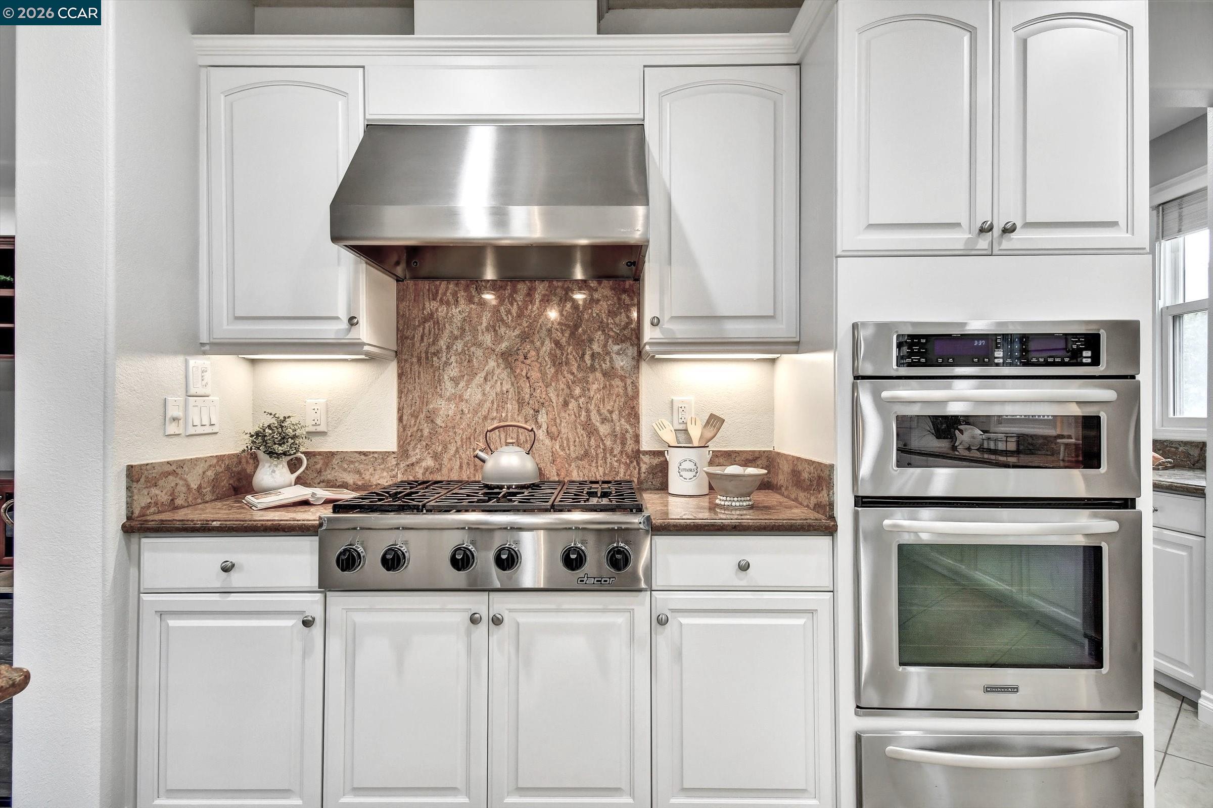 1018 Promenade Street Hercules, CA 94547 - Photo 22 of 60 a kitchen with granite countertop a stove oven and a white cabinets