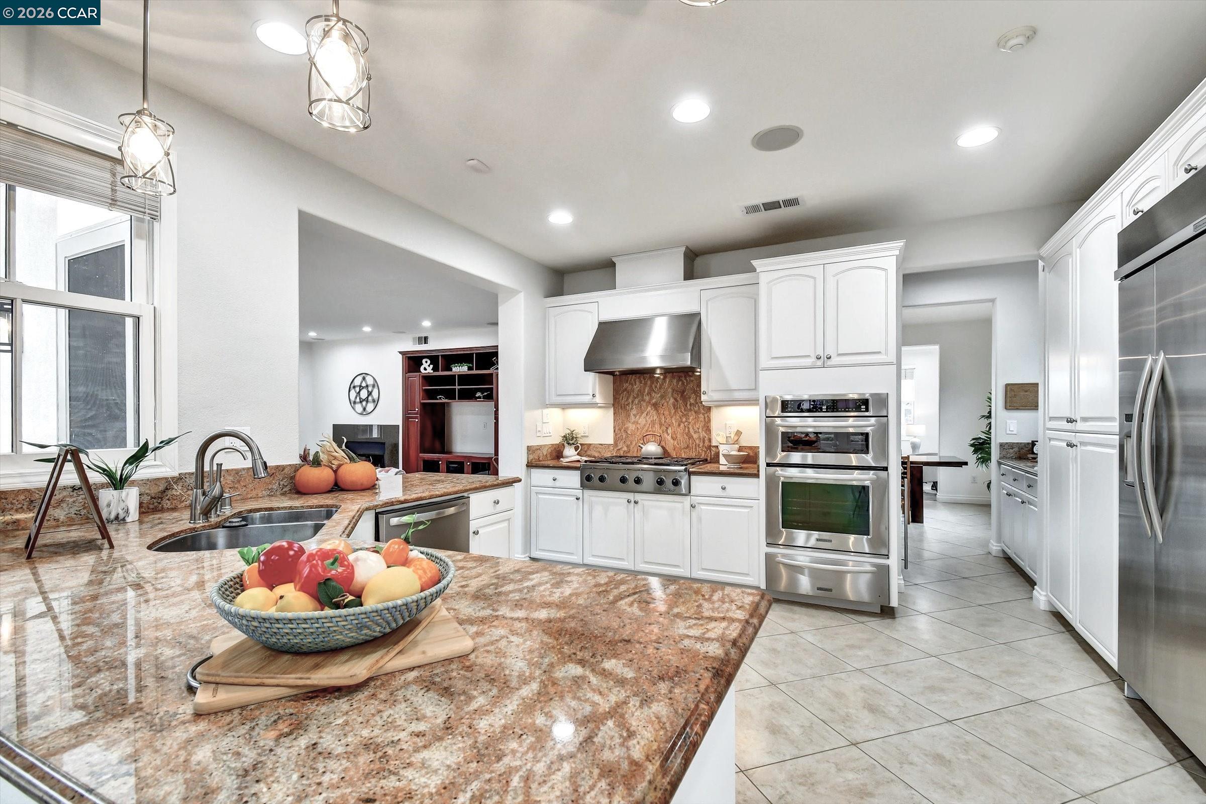 1018 Promenade Street Hercules, CA 94547 - Photo 23 of 60 a kitchen with stainless steel appliances kitchen island granite countertop a sink and cabinets