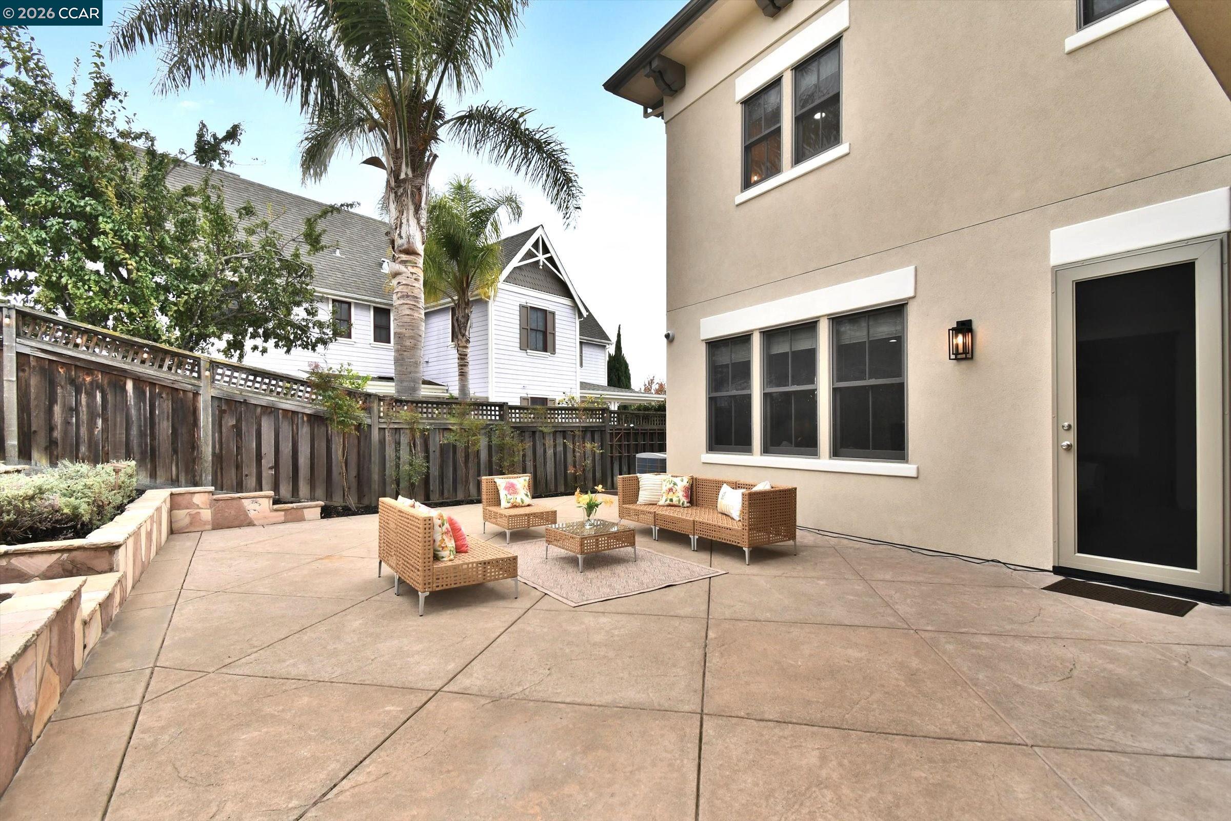 1018 Promenade Street Hercules, CA 94547 - Photo 44 of 60 a view of a patio with couches and chairs under an umbrella with wooden fence