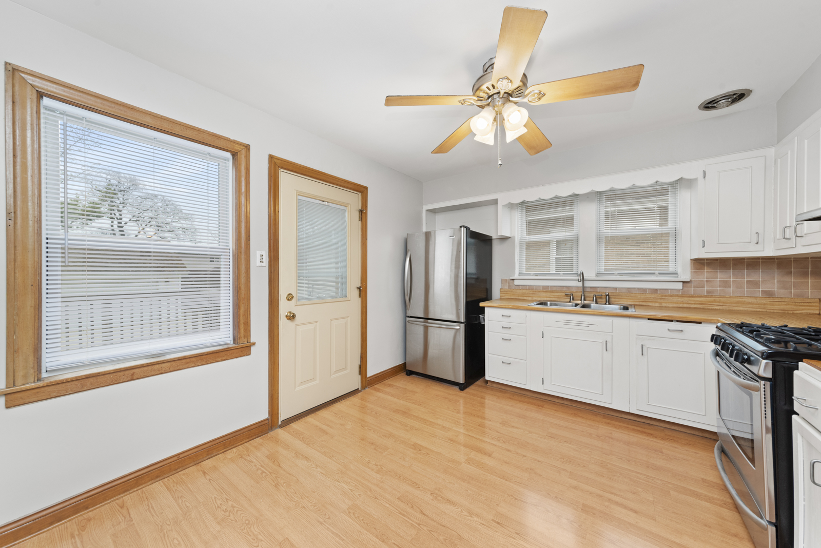 627 Spring Road Elmhurst, IL 60126 - Photo 6 of 20 a kitchen with stainless steel appliances granite countertop a refrigerator a sink dishwasher a stove with white cabinets and wooden floor