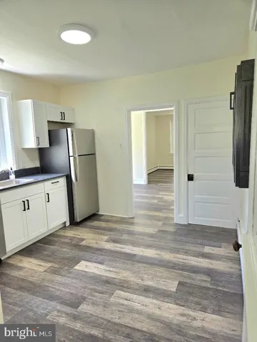 a view of a kitchen with refrigerator stove and wooden floor