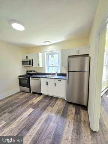a kitchen with a refrigerator a sink and a stove top oven