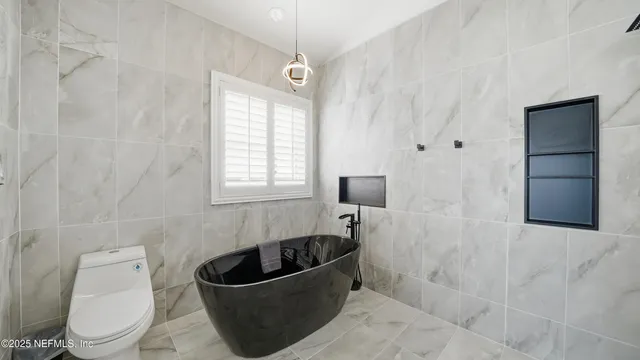 a kitchen with stainless steel appliances granite countertop white cabinets sink and window