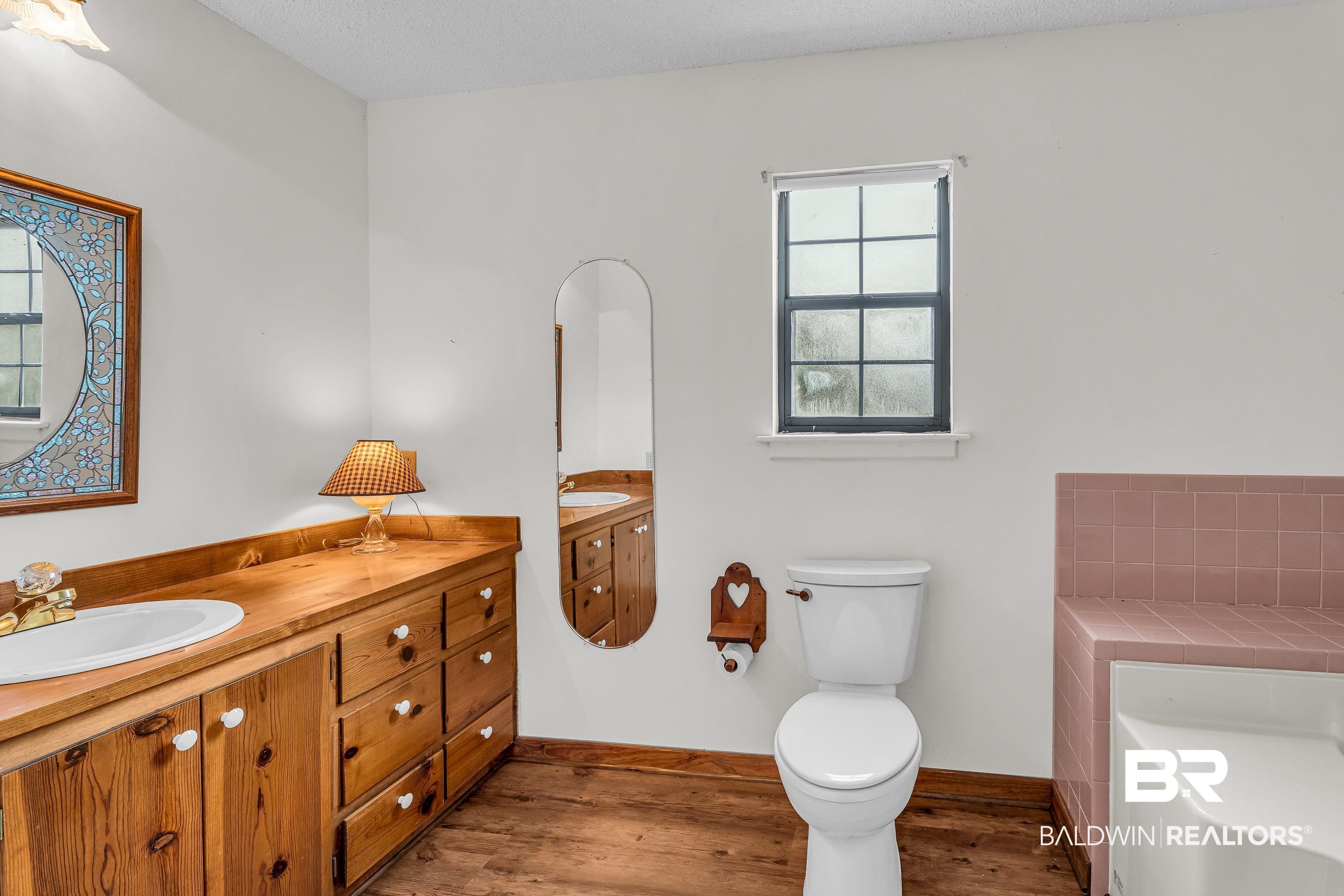 8317 Bryant's Lndg Road Stockton, AL 36579 - Photo 24 of 28 Bathroom with light wood finished floors, vanity, a tub to relax in, and a textured ceiling