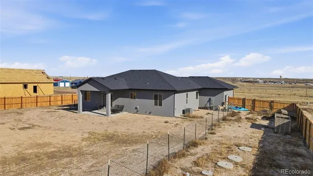 a large house with a large pool and lawn chairs