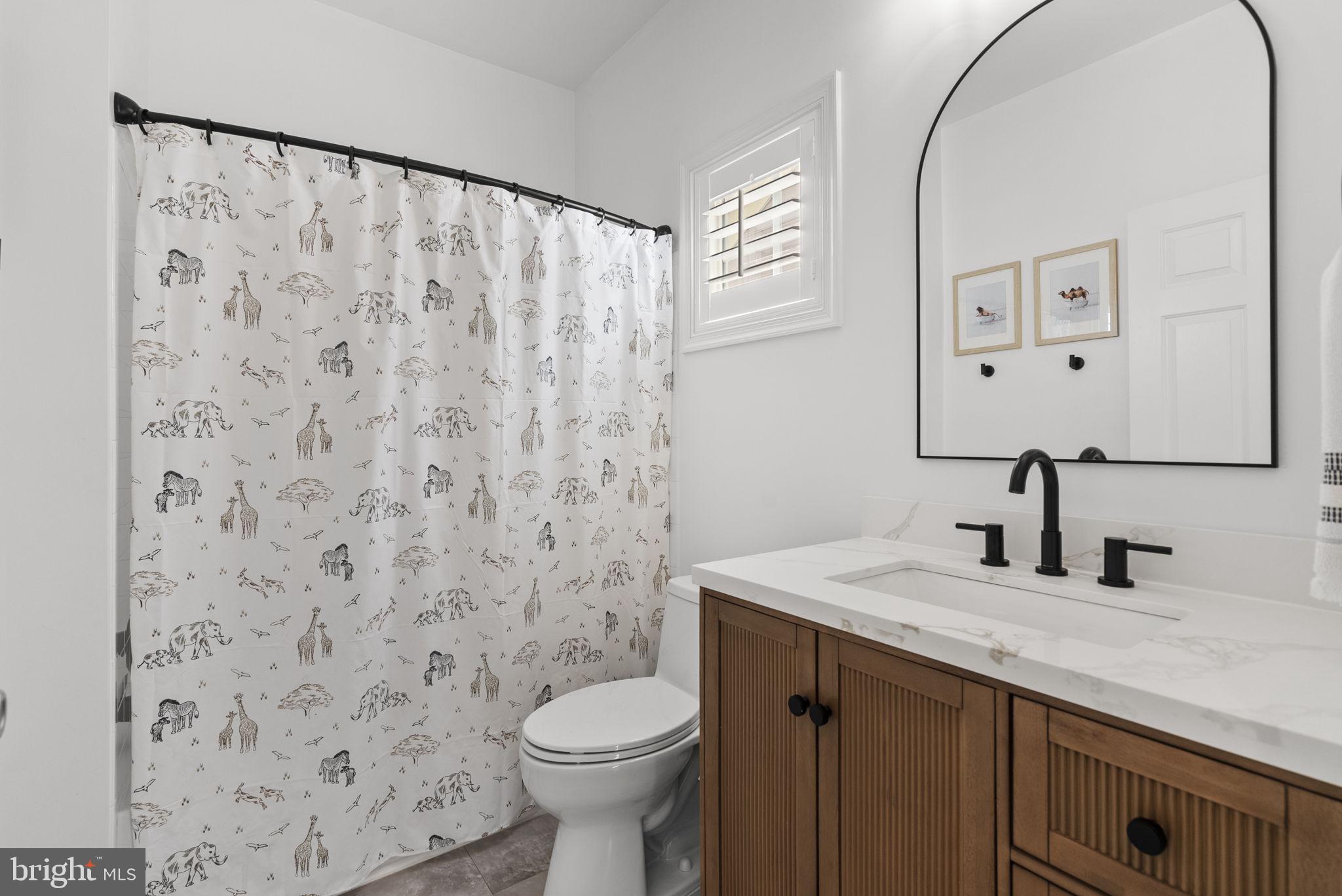 1339 Main Street Gaithersburg, MD 20878 - Photo 40 of 73 a bathroom with a granite countertop sink a toilet and a mirror