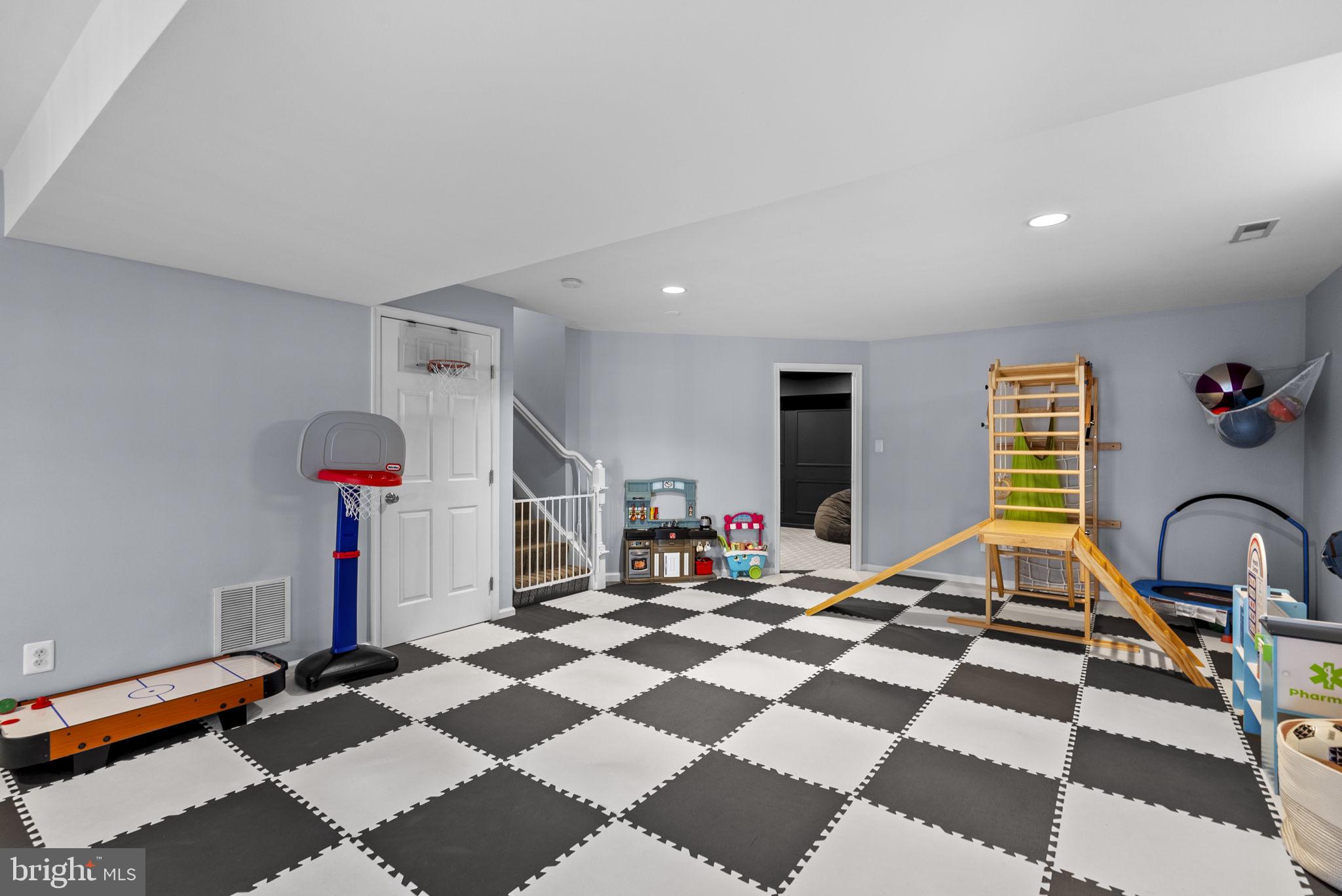1339 Main Street Gaithersburg, MD 20878 - Photo 43 of 73 a living room with a black white checkered floor with a gaming machine and appliances