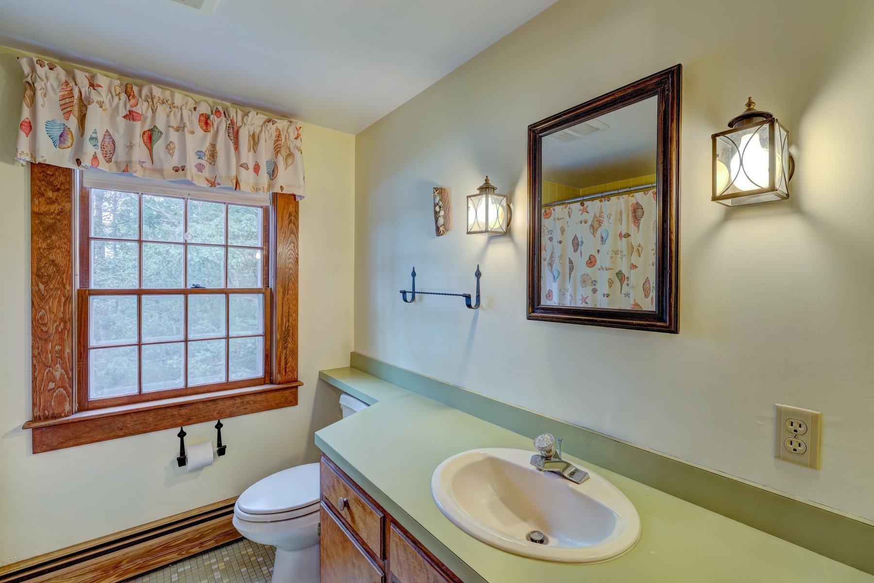 40 Viking Road Orleans, MA 02653 - Photo 14 of 27 a bathroom with a toilet sink a mirror and window