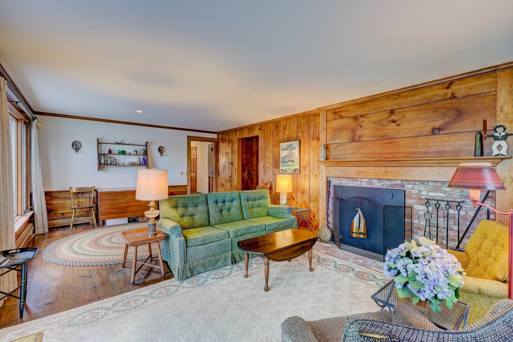 40 Viking Road Orleans, MA 02653 - Photo 4 of 27 a living room with furniture a fireplace and a table