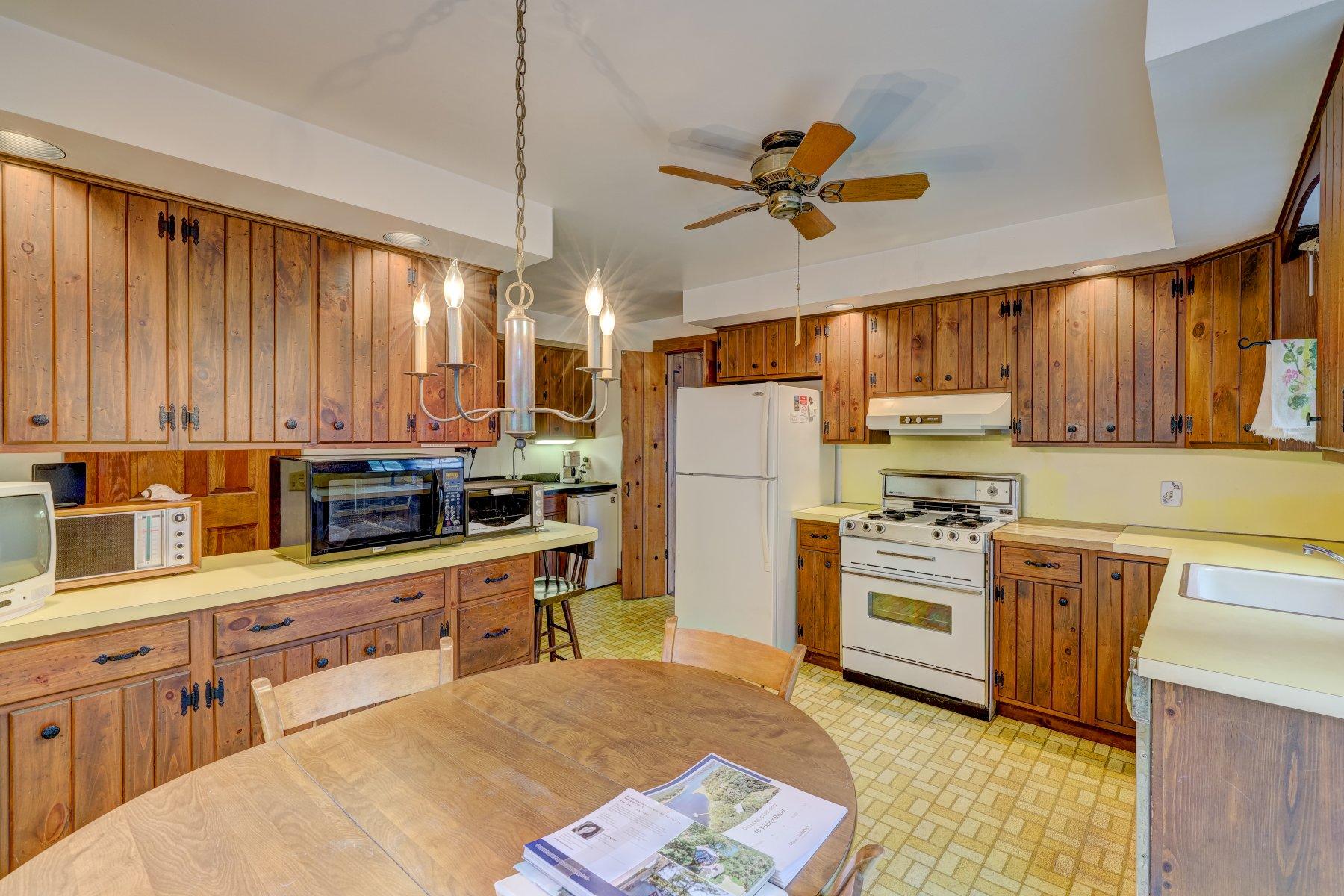 40 Viking Road Orleans, MA 02653 - Photo 6 of 27 a kitchen with stainless steel appliances granite countertop a refrigerator a stove top oven a sink dishwasher and white cabinets with wooden floor