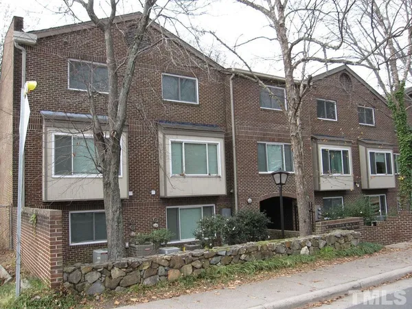 a front view of a house with plants and trees
