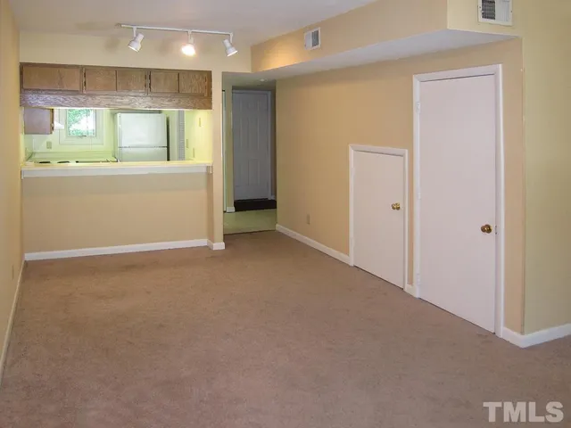 a view of an empty room with a kitchen