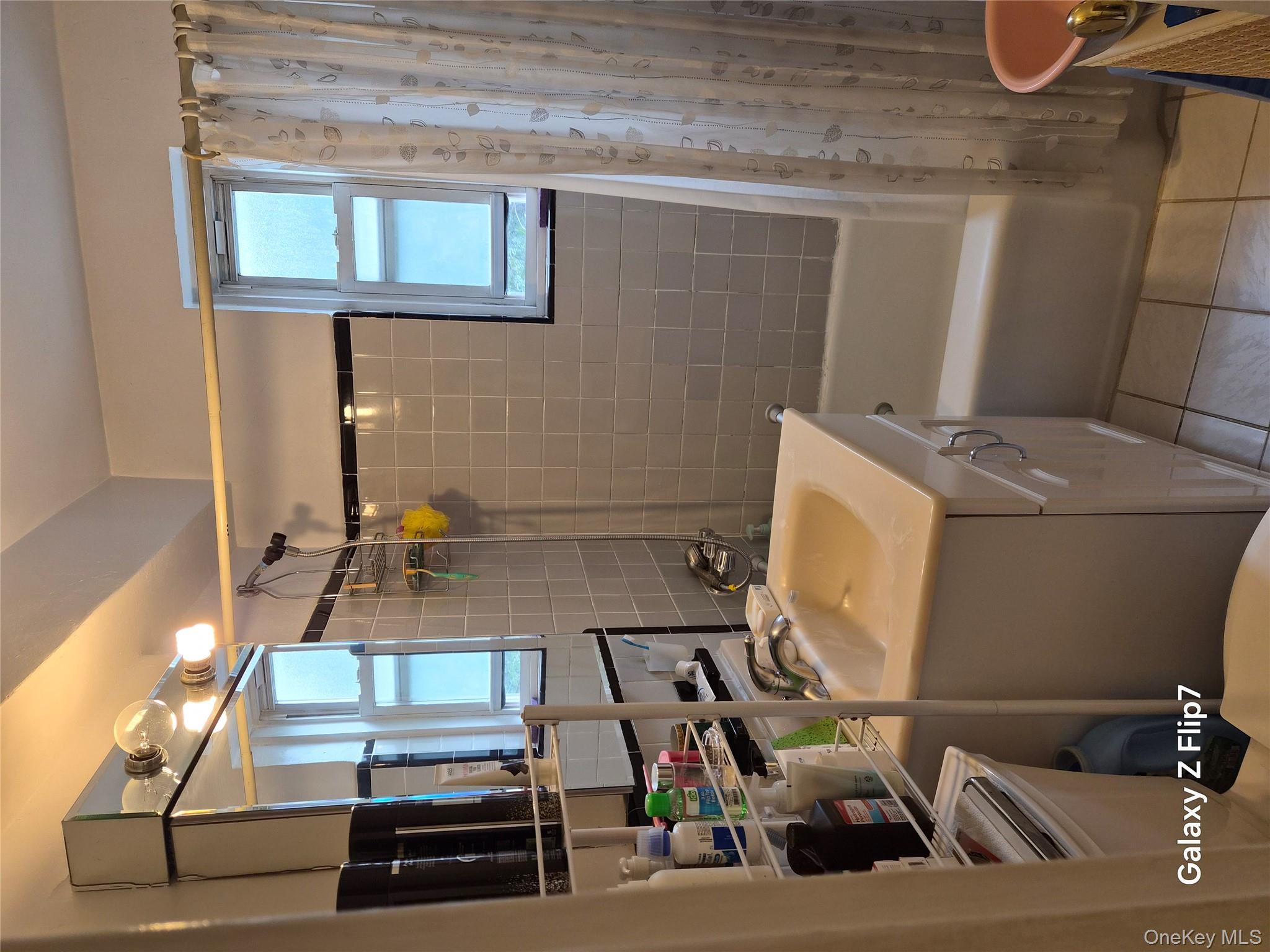 39-65 51st Street, Unit 4B Queens, NY 11377 - Photo 8 of 10 a bathroom with a sink a toilet and shower