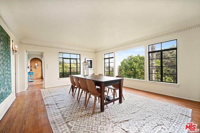 a dining room with furniture window and wooden floor