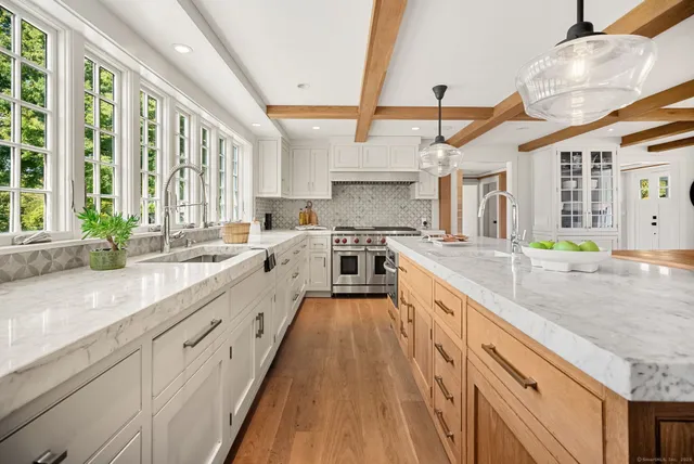 a large kitchen with stainless steel appliances lots of counter space and a sink