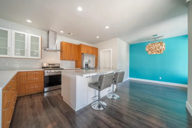 a kitchen with stainless steel appliances granite countertop a refrigerator and a stove
