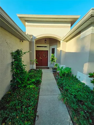 a view of an empty room and window and chandelier fan