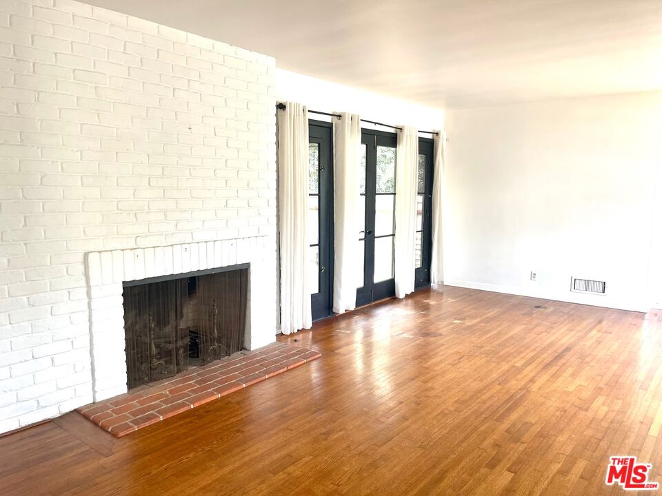 101 Larkin Place Santa Monica, CA 90402 - Photo 11 of 13 a view of empty room with wooden floor and fireplace