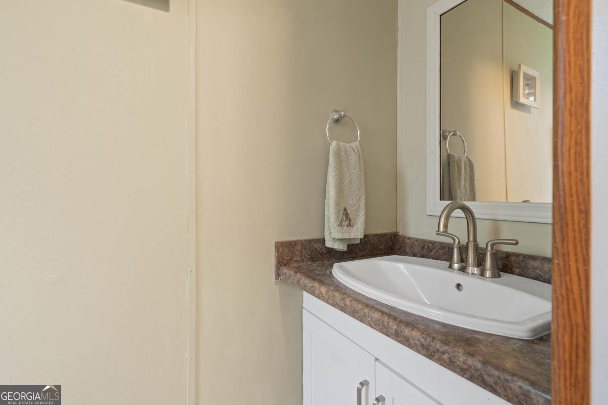 180 De Jarnette Road Southeast Eatonton, GA 31024 - Photo 11 of 66 a bathroom with a granite countertop sink and a mirror