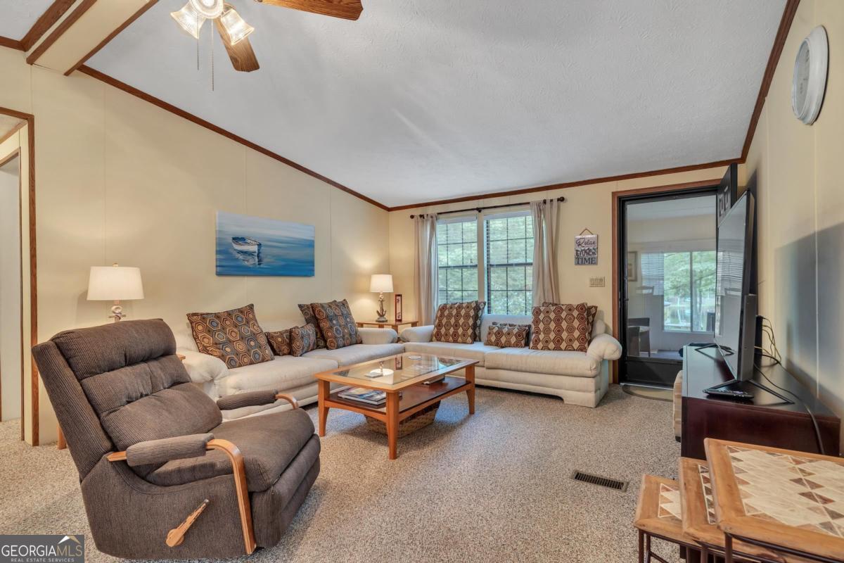 180 De Jarnette Road Southeast Eatonton, GA 31024 - Photo 14 of 66 a living room with furniture and a large window