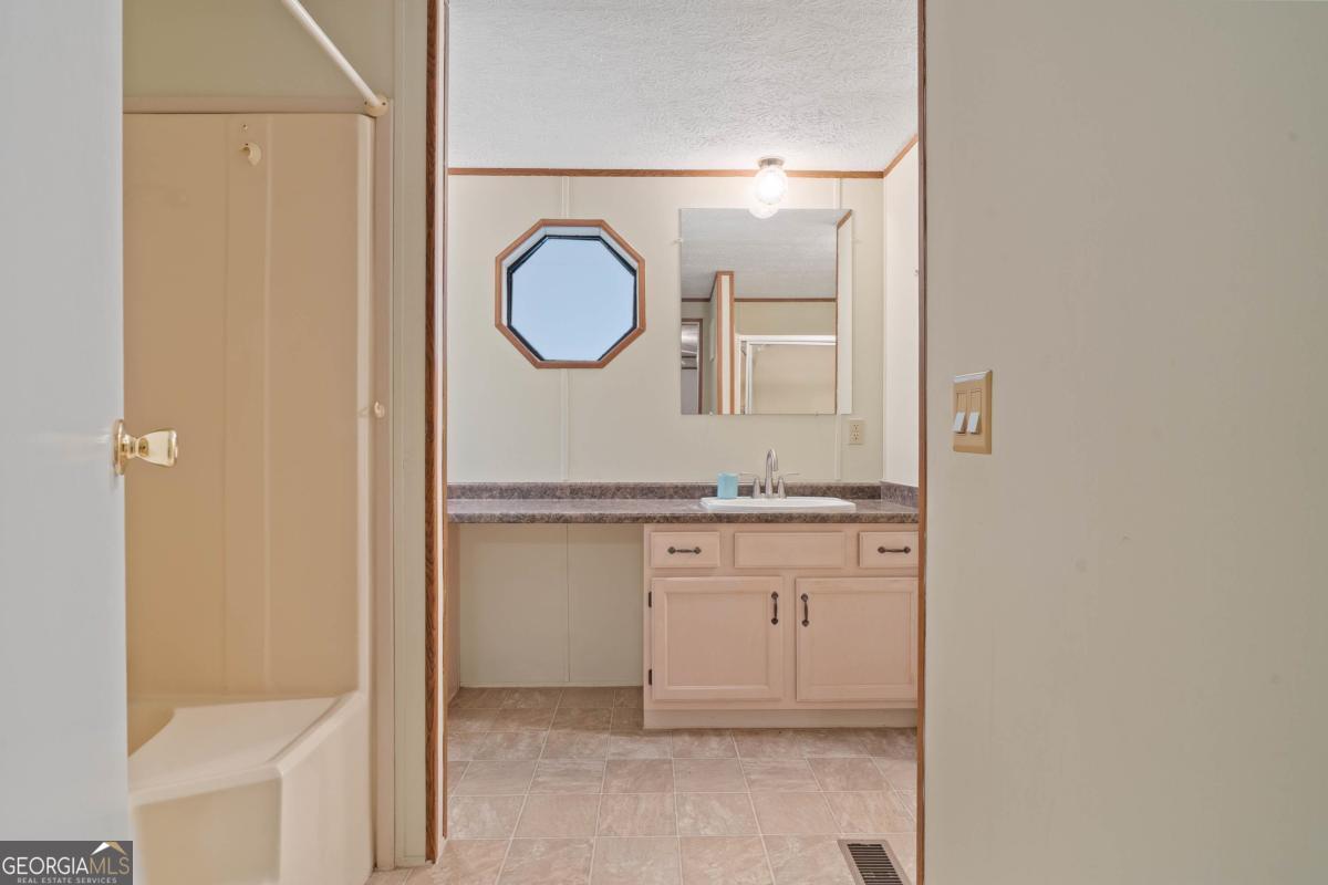 180 De Jarnette Road Southeast Eatonton, GA 31024 - Photo 20 of 66 a bathroom with a double vanity sink and a mirror