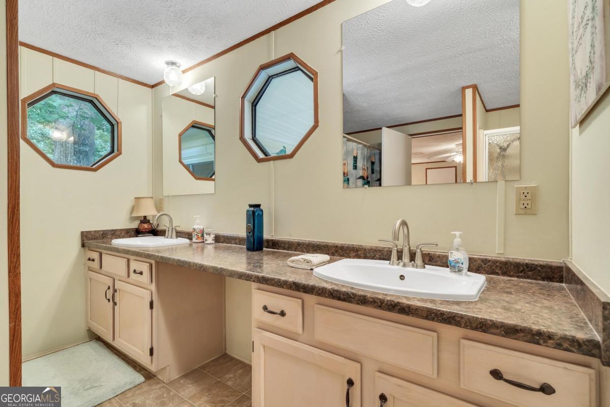 180 De Jarnette Road Southeast Eatonton, GA 31024 - Photo 22 of 66 a bathroom with a granite countertop double vanity sink and a mirror