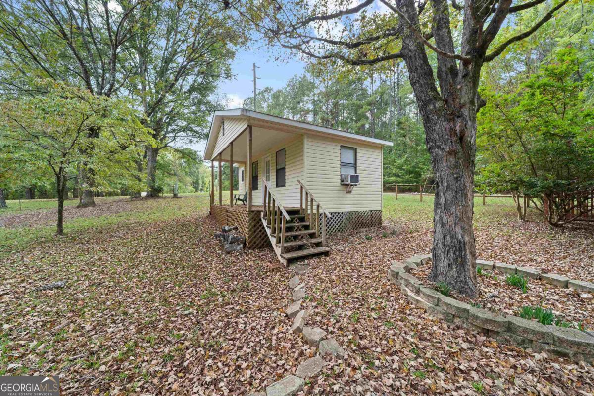 180 De Jarnette Road Southeast Eatonton, GA 31024 - Photo 40 of 66 a view of a house with a yard and large trees
