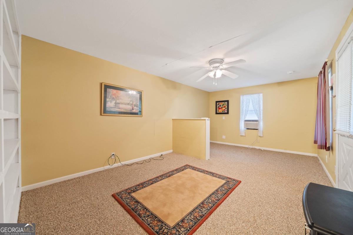 180 De Jarnette Road Southeast Eatonton, GA 31024 - Photo 43 of 66 a living room with furniture and a ceiling fan