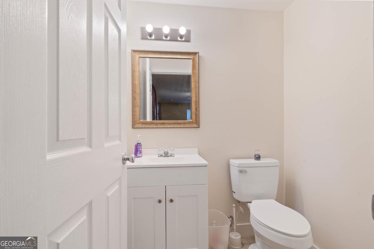 180 De Jarnette Road Southeast Eatonton, GA 31024 - Photo 46 of 66 a bathroom with a toilet sink vanity and mirror