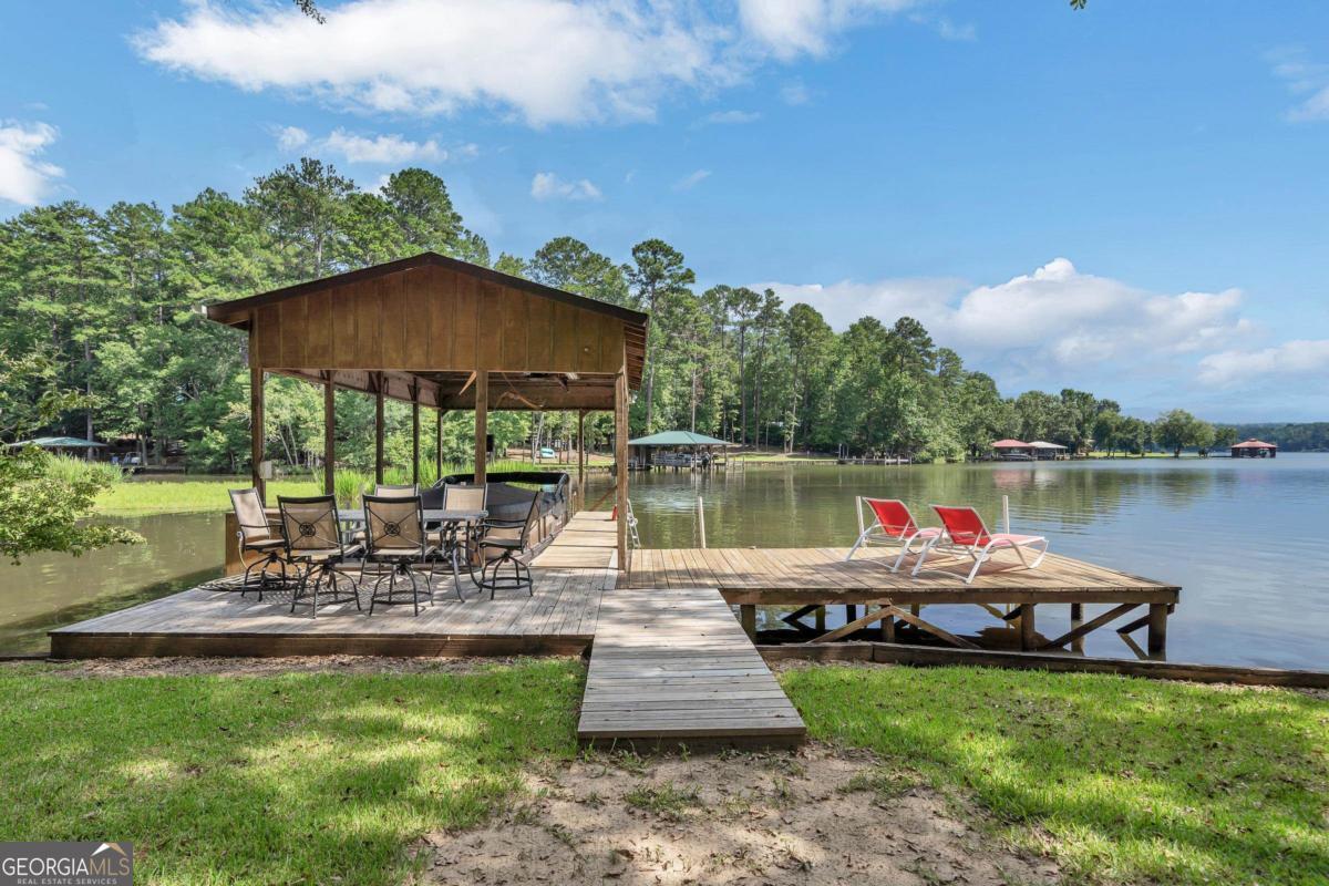 180 De Jarnette Road Southeast Eatonton, GA 31024 - Photo 54 of 66 a view of a patio with chairs next to a yard
