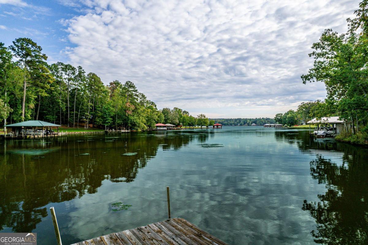 180 De Jarnette Road Southeast Eatonton, GA 31024 - Photo 55 of 66 a view of a lake with a yard and large trees