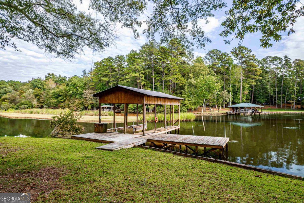 180 De Jarnette Road Southeast Eatonton, GA 31024 - Photo 57 of 66 a view of a lake with a yard and a large tree