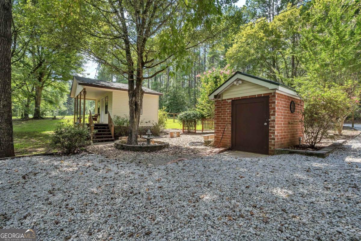 180 De Jarnette Road Southeast Eatonton, GA 31024 - Photo 63 of 66 a view of a house with a yard and large tree