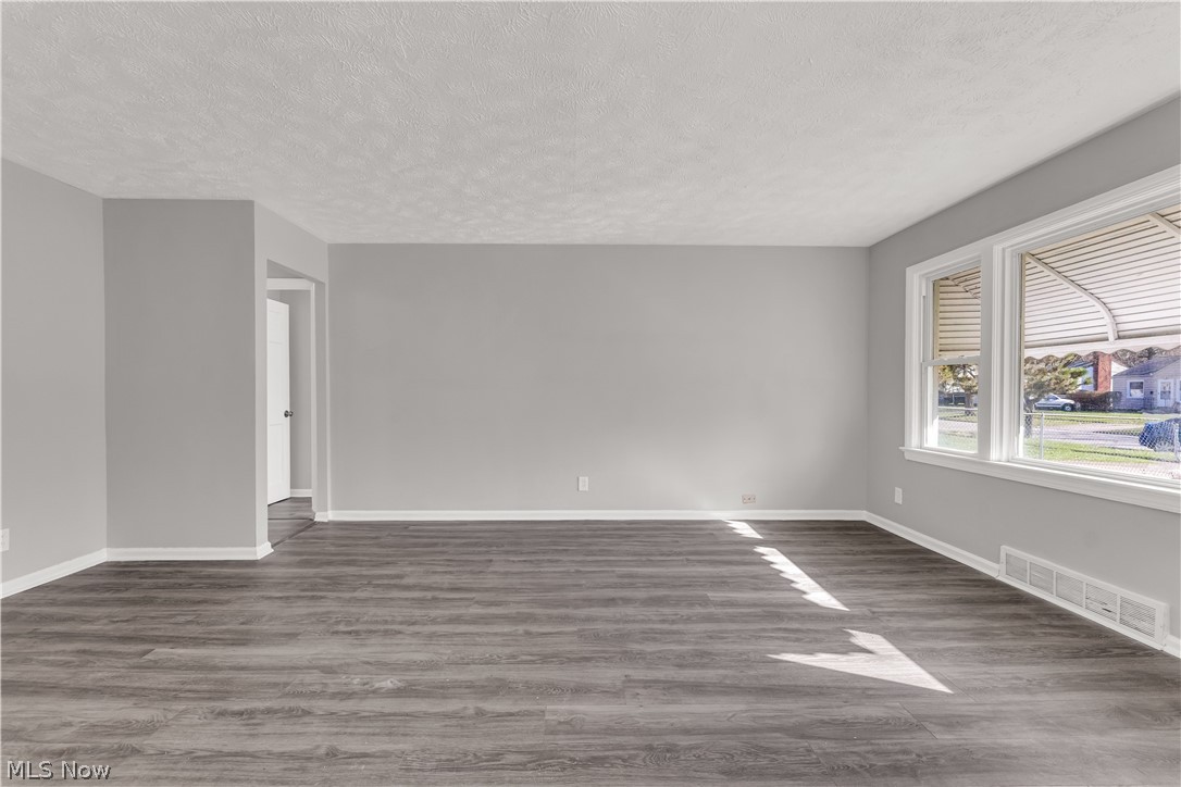 2521 Greenvale Road Cleveland, OH 44121 - Photo 8 of 23 Spacious interior featuring wood-finish flooring, light gray wall paint, white trim, and multiple large windows with horizontal blinds