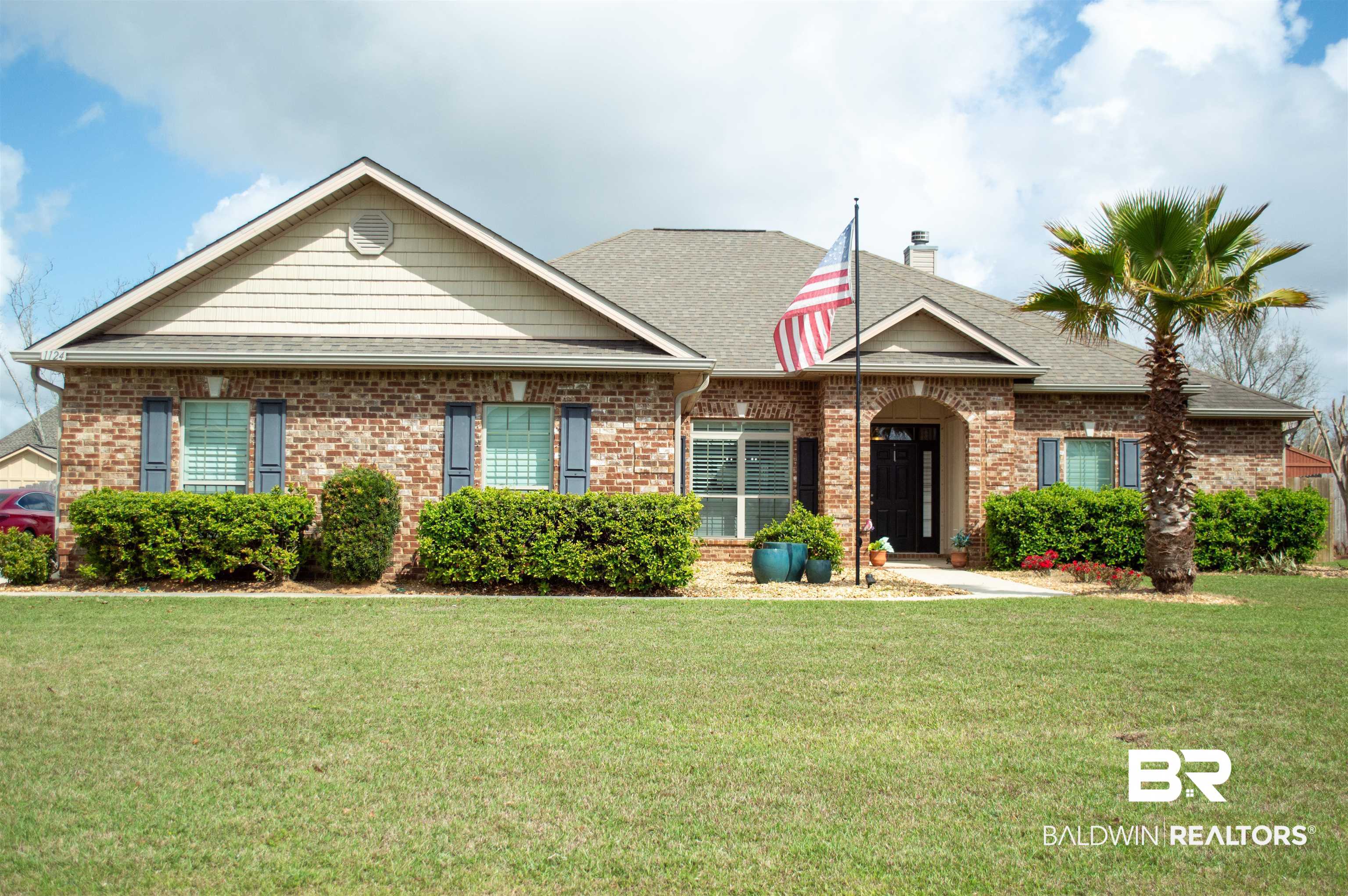 1124 West Orlando Drive Foley, AL 36535 - Photo 1 of 51 View of front of house featuring a shingled roof, a front yard, and brick siding
