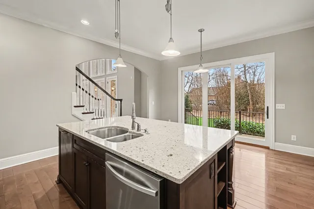 a kitchen that has a sink a table and chairs in it